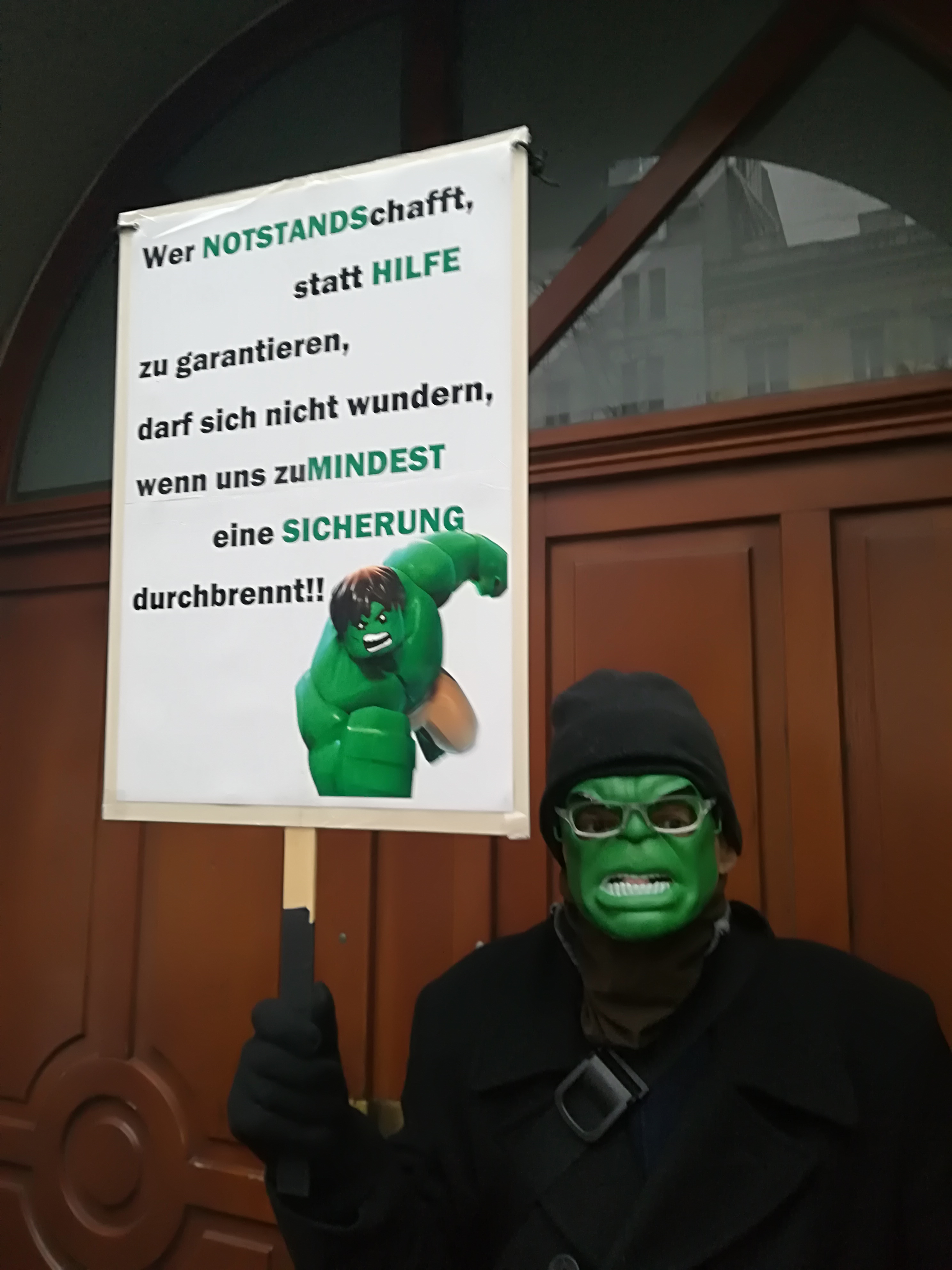 Hulk mit Protestplakat gegen die Abschaffung der Notstandshilfe auf einer Demonstration im Jänner 2018